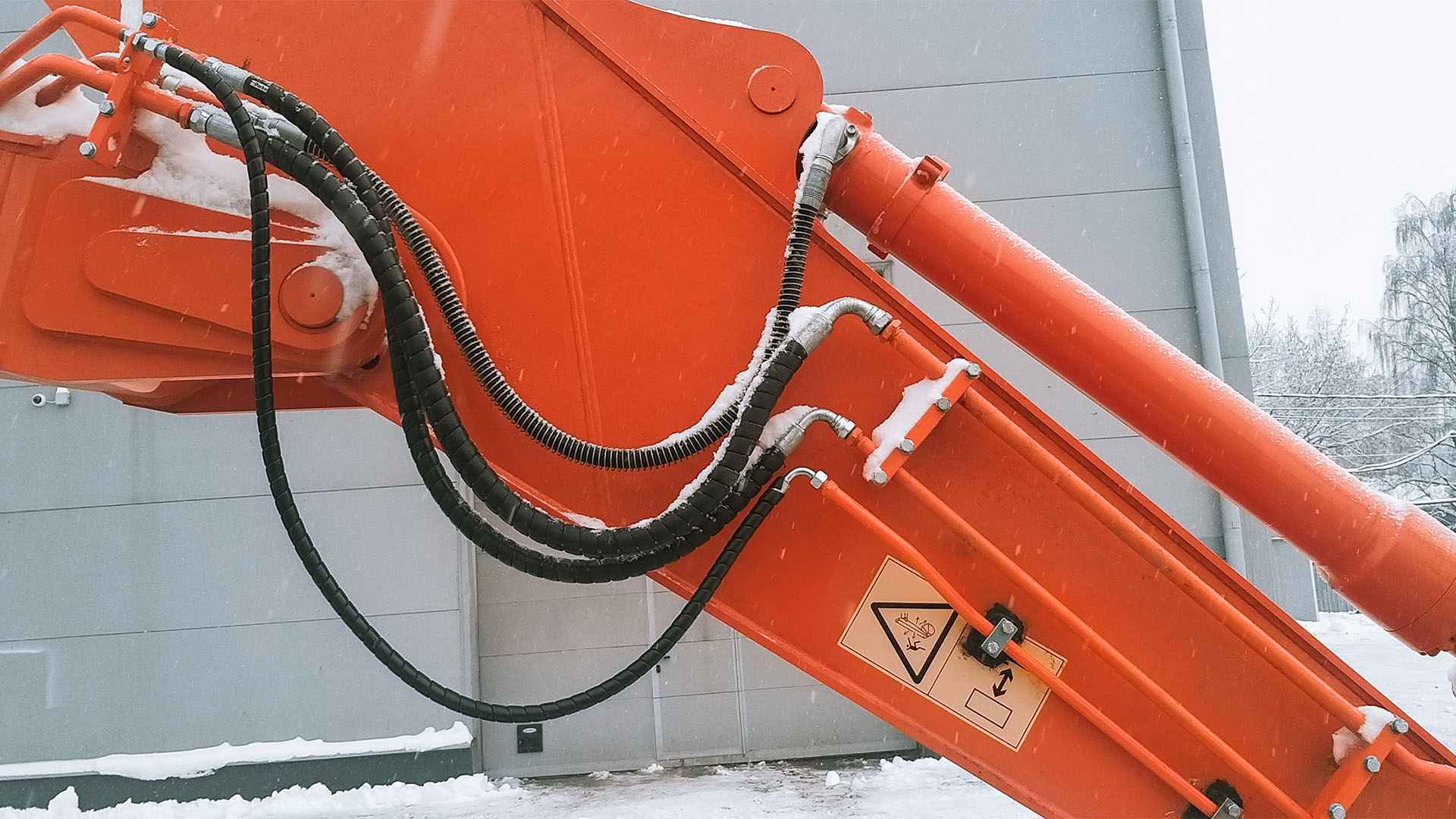Фотография стрелы экскаватора в зимний период, оборудованной гидроразводкой