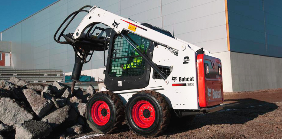 Фото мини погрузчика Bobcat S450 в процессе дробления кусков асфальта гидромолотом