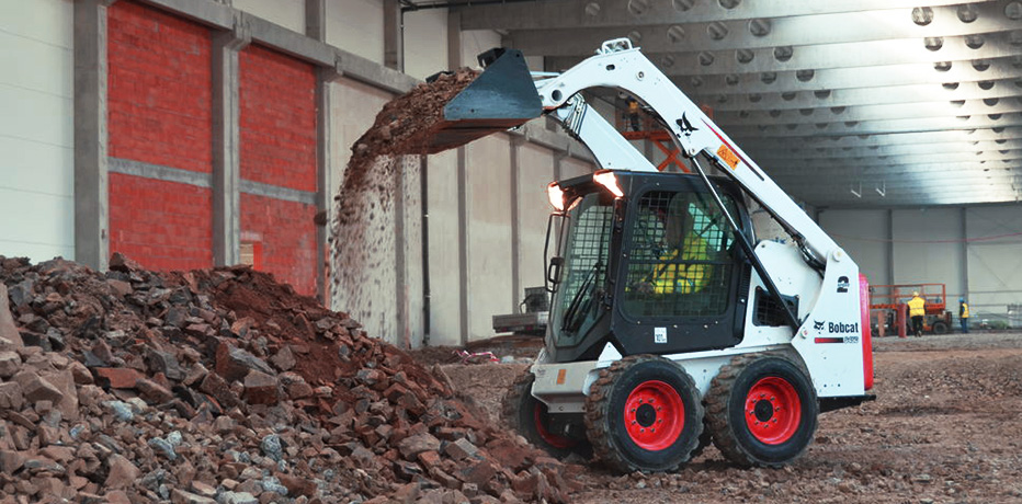 Фото мини погрузчика Bobcat S450 во время перевалки каменного лома
